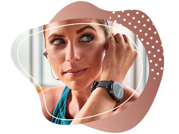 Žena s Garmin Vívoactive hodinkami ve sportovním oblečení která si nasazuje sluchátka, garmin vivoactive